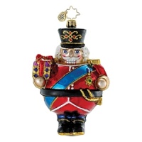 This jolly nutcracker, with a detailed top hat and medal, holds a Christmas gift.