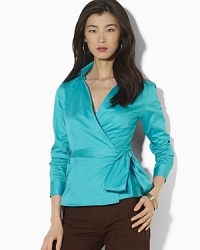 A feminine wrap blouse is crafted in luxurious cotton sateen for a modern, sophisticated look.