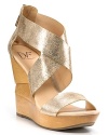 Sparkling leather straps wrap a sculpted wood wedge, a dizzying mix of glamour and natural beauty by DIANE von FURSTENBERG.