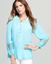 Intricate floral cutouts lend a touch of bohemian flair to a billowing silk Lilly Pulitzer blouse.