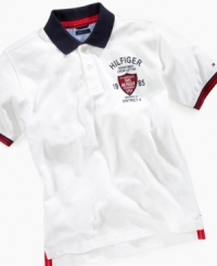 Newest way for him to wear the red, white, and blue: On this short-sleeved polo shirt from Tommy Hilfiger featuring a contrast collar, striped sleeve ribbing, and a logo patch.