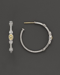 Faceted, oval-shaped canary crystals, flanked by hearts, bring romantic glamour to classic sterling silver hoop earrings.