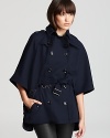 Ascend fashion ranks in a Burberry Brit cape featuring military-inspired accents and statement hardware. A fabric belt cinches the oversized silhouette for style that soldiers on.