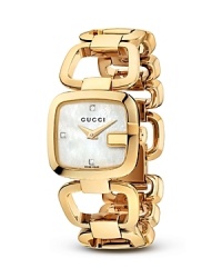 A Gucci bracelet watch with gold-tone links makes a luxe presentation with a mother of pearl face.