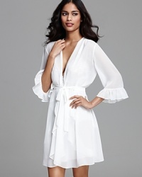 Exude elegance in a three-quarter sleeve wrap with ruffle trim.