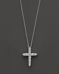 A diamond cross necklace. With signature ruby accent. Designed by Roberto Coin.