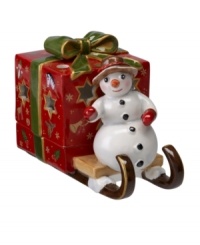 A snowman carries a brilliant surprise on the back of his sleigh in this beautifully crafted candle holder from Villeroy & Boch. Light shines through pierced stars in a present wrapped in charming vintage style.