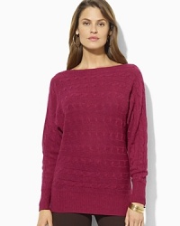 A unique horizontal cable knit and dolman sleeves lend modern appeal to a chic boatneck sweater.