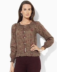 A slightly sheer georgette blouse is rendered with an allover floral pattern, adding feminine allure to any wardrobe.