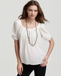 Dainty neck pleating and pin-tucked sleeves lend panache to this breezy silk top from Joie.