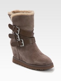 Shearling-lined essential of buttery suede with a hidden wedge and leather buckled straps. Suede-covered wedge, 3¼ (80mm)Rubber platform, ¾ (20mm)Compares to a 2½ heel (65mm)Shaft, 7Leg circumference, 10Suede upper with leather adjustable buckle strapsShearling liningRubber trek solePadded insoleImportedOUR FIT MODEL RECOMMENDS ordering one half size up as this style runs small. 