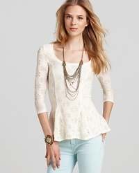 Daisy burnouts add life to a Free People top, while a trend-right peplum hem brings this blouse to full bloom.