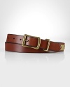 An antiqued brass buckle and decorative ring lend this classic leather belt the feel of a vintage favorite