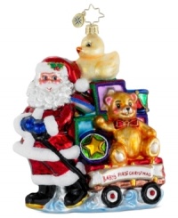 Pull out all the stops for your baby's first Christmas with an ornament handcrafted by Christopher Radko. Santa delivers a wagon stacked with toys in bright, shiny colors to commemorate the happy occasion.