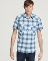 Classic Western styling meets detailed tailoring and an allover plaid design in this cowboy cool short-sleeve button-down from Lucky Brand.