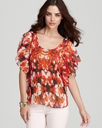 Enlivened by a statement-making print, this flouncy GUESS top is sure to turn heads all season long.