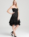 An elaborate ostrich feather hem decorates a strapless silhouette from Badgley Mischka, rendered in lace.