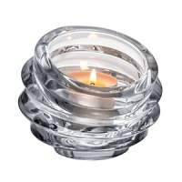 In an artful interpretation of an echo wave, ripples of reflective glass travel upward to create this unique votive holder by Orrefors.