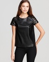 The classic tee goes rocker luxe as sleek faux-leather and studded sleeves toughen up this DKNYC top. Style with skinny jeans and rock n' roll to the top of the fashion charts.