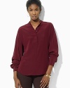 Rendered in skin-caressing silk, a chic tunic is crafted with dolman sleeves for modern appeal.