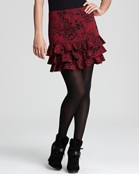 A rich hue and ruffled hem enliven an animal-print DKNY skirt, layered over sheer tights for a roaring fashion statement.