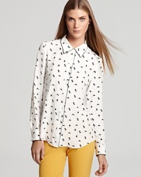 A whimsical bird print enriches this elegant Theory top crafted from pure silk.