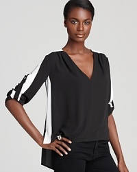 A bold contrast bewitches this BCBGMAXAZRIA top with a striking stripe of white and relaxed, boxy fit--ideal for pairing with slim skinny jeans.