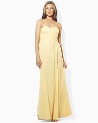 Exuding sweeping glamour in a floor-length silhouette with a delicate shirred neckline, an elegant gown is designed in airy georgette for ethereal charm.