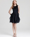 Decadent organza ruffles dress up the skirt of a sophisticated, sleeveless silhouette from Halston Heritage.