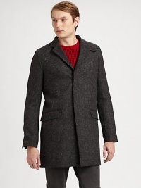 A Japanese wool coat with an elongated silhouette and concealed button closure. Notched collarConcealed button closureFlap pocketsAbout 35 from shoulder to hemWoolDry cleanImported