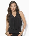 A fluid silk blouse is crafted in a sleeveless silhouette with an elegant ruffle at the front.