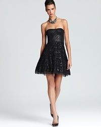 Matte black sequins lend understated sparkle to a strapless BCBGMAXAZRIA dress, crafted with a flared, tiered skirt for a playful finish.