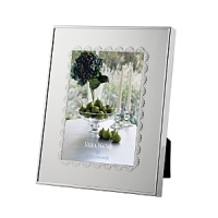 A scalloped border inspired by delicate lace lends classically feminine style to this silver-plated frame from Vera Wang.