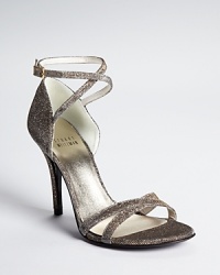 In shimmering fabric, Stuart Weitzman's shining evening sandals subtly shift from silver to gold with a single step.