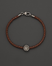 Silver Gucci charm on a braided brown natural leather bracelet.