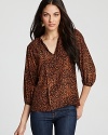 In lively leopard, Tucker's animal printed top showcases a split neck with tie details.