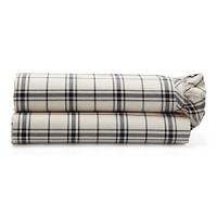 Dramatic black-and-cream checked sheets and pillowcases are edged in feminine pleated ruffles.