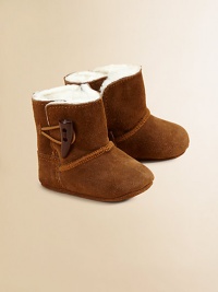 Precious baby booties crafted in ultra-plush suede with shearling lining and toggle button closure.Toggle closureLeather upperShearling leather liningLeather solePadded insoleImported