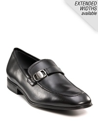 Sleek and stylish slip-on dress shoes with leather strap and buckle detail at top. Round toe. Gancini insignia etched on buckle and heel. Leather sole with slightly stacked heel.