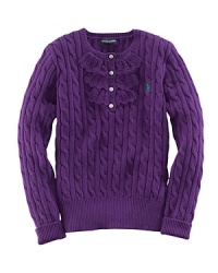 A traditional cable-knit sweater takes a feminine turn with delicate ruffle trim along the buttoned front.