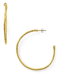 Designer Alexis Bittar plays rough with these textured gold plated hoop earrings, boasting a simple shape and faceted finish.