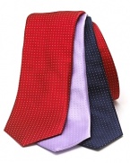 A wide silk tie embellished with a tonal pindot print.