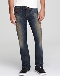 A multicolor patch adorns the back pocket of these heavily distressed and destroyed jeans, a powerfully cool design from none other than True Religion.