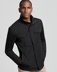 Streamlined and modern, a black waist-length zip up jacket from Theory adds instant style to transitional weather attire.