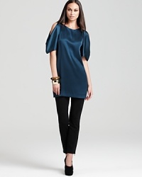 A luxurious silhouette and stunning cold shoulders imbue this DKNY tunic with modern elegance.