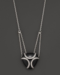 A bold sterling silver cage, glistening with diamonds, encases a gleaming black onyx stone. By Di MODOLO.