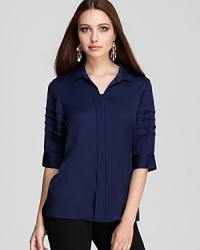 In sumptuous silk, this Elie Tahari blouse shows off pleated details and grosgrain accents for fashion-forward edge.