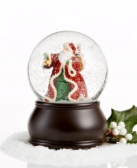 Deck the halls! Santa Claus, dressed in glittery garb, treks through the snow with his bag of gifts and lantern to light the way in this snow globe sure to bring cheer to your home.