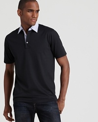 Michael Kors creates an interesting contrast with this unique polo, featuring a check collar and placket with a trim, modern fit.