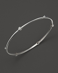 Faceted diamonds stud Roberto Coin's slim 18K. white gold bangle.